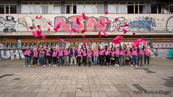 Investition in den öffentlichen Dienst Junge Beschäftigte des öffentlichen Dienstes vor einem leerstehenden, heruntergekommenen Gebäude