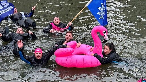 Eine Gruppe Menschen schwimmt in Neoprenanzügen in einem Fluss
